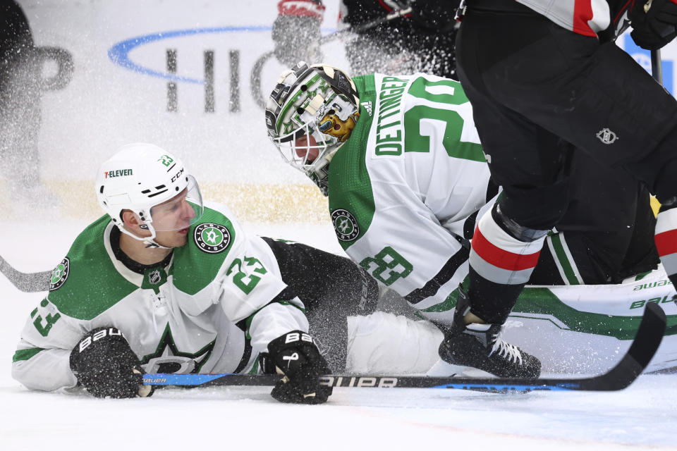 Dallas Stars defenseman Esa Lindell (23) slides into goaltender Jake Oettinger (29) during the first period of the team's NHL hockey game against the Buffalo Sabres on Tuesday, Feb. 6, 2024, in Buffalo, N.Y. (AP Photo/Jeffrey T. Barnes)