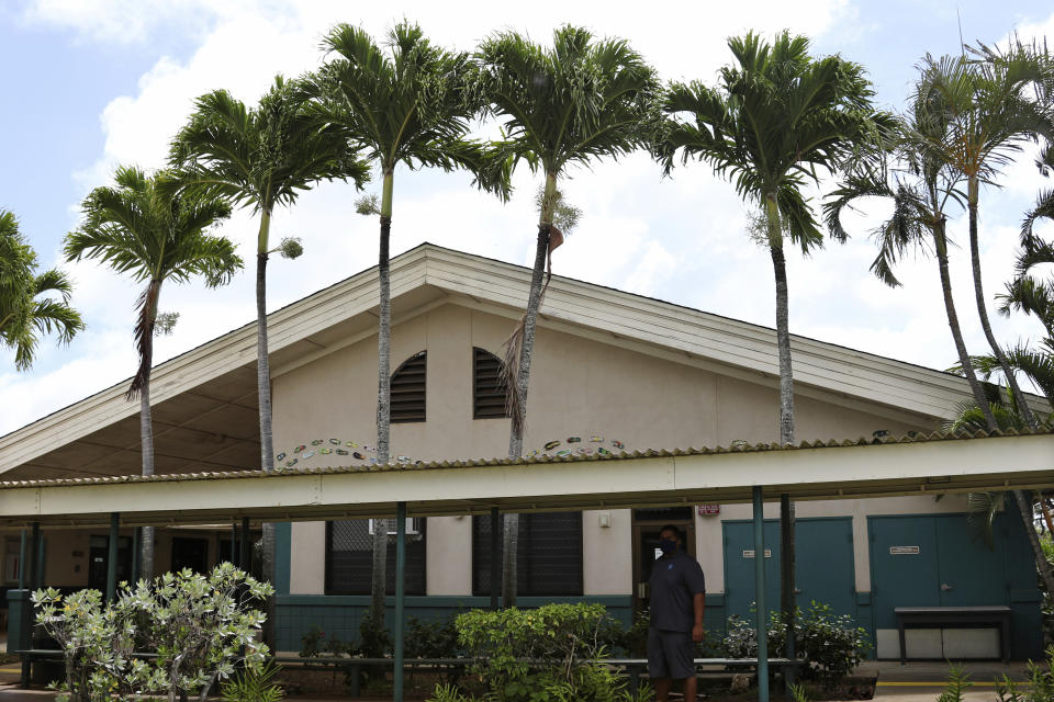 Principal Keoki Fraser stands next to a classroom at Aikahi Elementary School in Kailua, Hawaii on Tuesday, July 28, 2020. While Hawaii has one of the lowest rates of cases per capita in the country and many of its schools have open-air campuses, the challenges of returning kids full time to classrooms may still be insurmountable. (AP Photo/Jennifer Sinco Kelleher)