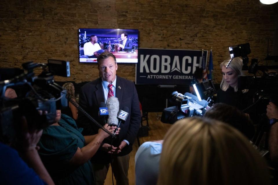 Former Secretary of State Kris Kobach speaks with reporters at an election night event in Topeka. Kobach claimed victory in the Republican attorney general primary Tuesday night.