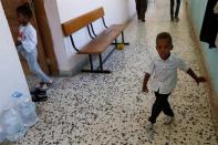 A displaced boy who left his home with his family after clashes is seen at a school used as a shelter in Abu Slim district in Tripoli