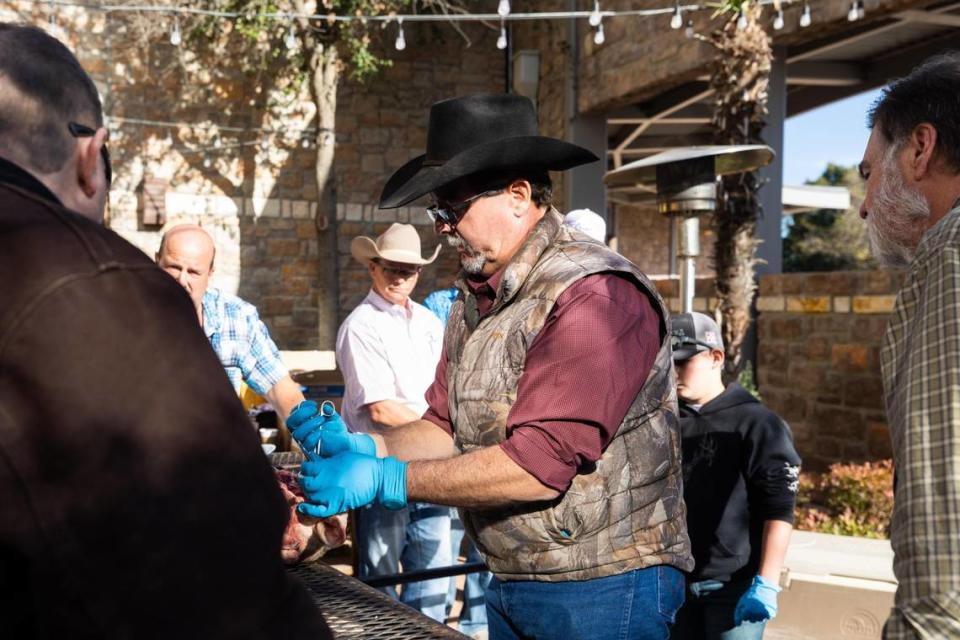 Kent Munden, an animal identification coordinator at USDA APHIS, draws samples from a sheep head to demonstrate how to collect samples for chronic wasting disease (CWD) testing during the Deer Breeders Corp. auction in January 2022 at Horseshoe Bay Resort.