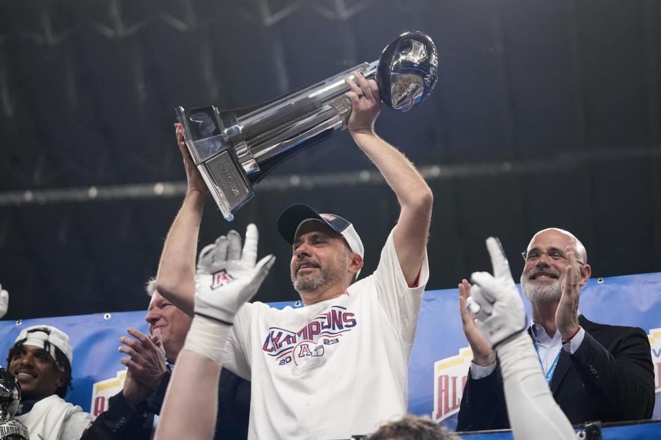 Jedd Fisch hoists a trophy.