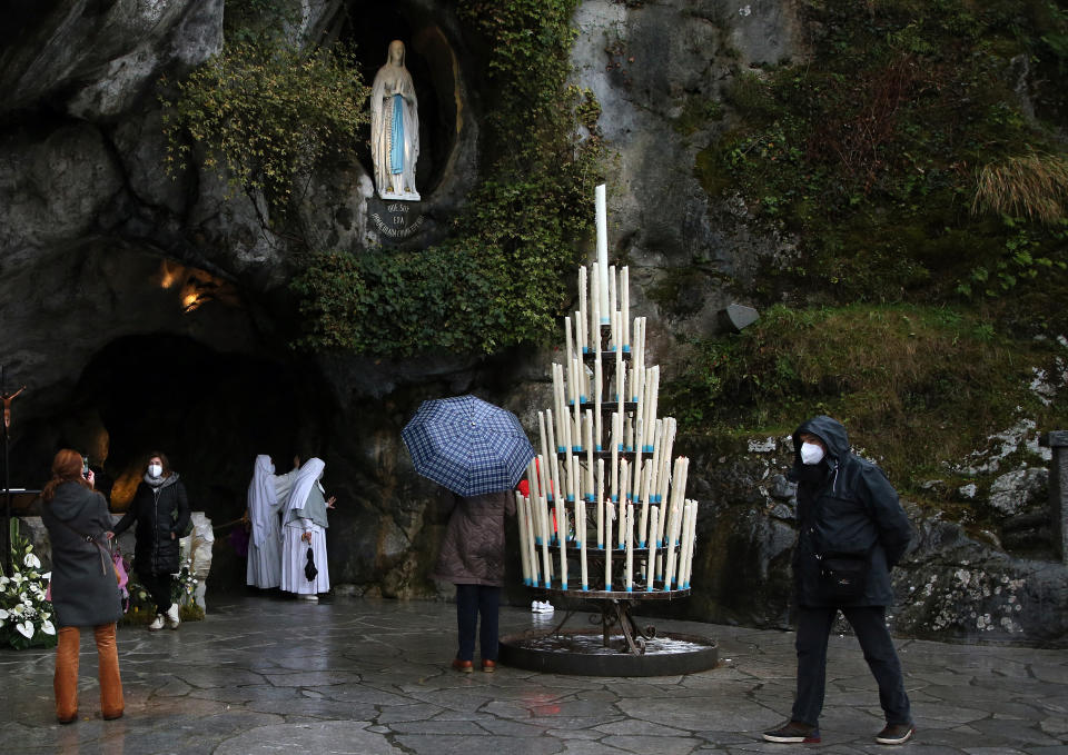 Pilgrims pray at the Roman Catholic shrine in Lourdes, southwestern France, Friday, Feb.11, 2022. On Friday, May 17, 2024, the Vatican will issue revised norms for discerning apparitions "and other supernatural phenomena," updating a set of guidelines first issued in 1978. (AP Photo/Bob Edme, File)