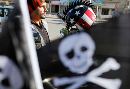 A member of the Iraq Bikers, the first Iraqi biker group, stands behind a skull flag in Baghdad, Iraq December 28, 2018. REUTERS/Thaier Al-Sudani