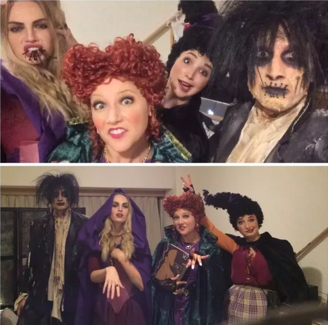 Four people in the characters' costumes, including wigs and garish makeup