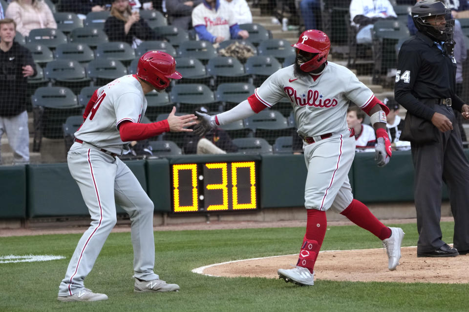 Philadelphia Phillies' Josh Harrison, right, celebrates with Jake Cave after they scored on Harrison's two-run home run off Chicago White Sox relief pitcher Jimmy Lambert during the seventh inning in the first game of a baseball doubleheader Tuesday, April 18, 2023, in Chicago. (AP Photo/Charles Rex Arbogast)