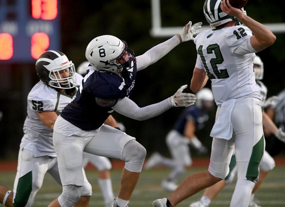 Medway's Brett Curran reaches for Westwood quarterback Brendan Donegan during the first half at Medway High School, Sept. 29, 2022.