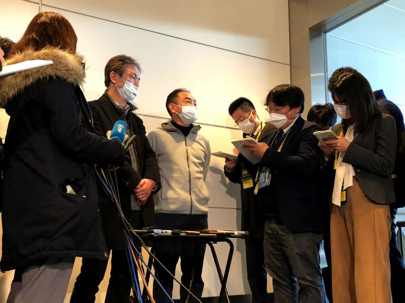 Wearing masks, Takeo Aoyama and Takayuki Kato, who were evacuated by a Japanese chartered plane from Wuhan, speak to reporter after they arrive at Haneda airport in Tokyo