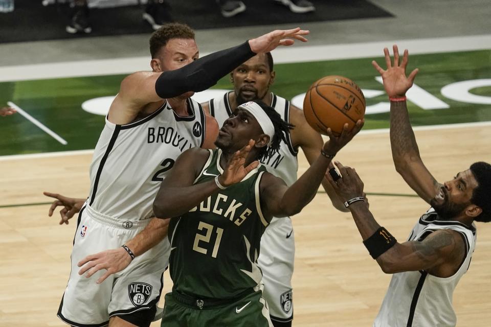 Milwaukee Bucks' Jrue Holiday shoots in traffic during the second half of an NBA basketball game against the Brooklyn Nets Sunday, May 2, 2021, in Milwaukee. (AP Photo/Morry Gash)