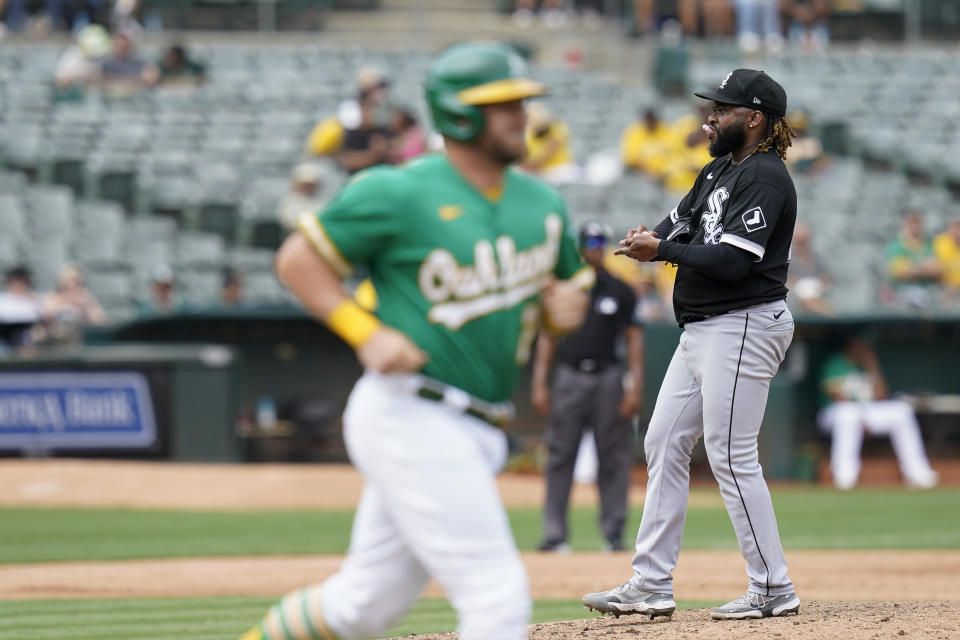 Chicago White Sox starting pitcher Johnny Cueto, right, looks toward home plate after walking Oakland Athletics' Stephen Vogt, foreground, during the fifth inning of a baseball game in Oakland, Calif., Sunday, Sept. 11, 2022. (AP Photo/Godofredo A. Vásquez)