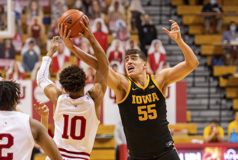 Indiana guard Rob Phinisee (10) and Iowa center Luka Garza (55) battle for the ball during the first half of an NCAA college basketball game, Sunday, Feb. 7, 2021, in Bloomington, Ind. (AP Photo/Doug McSchooler)