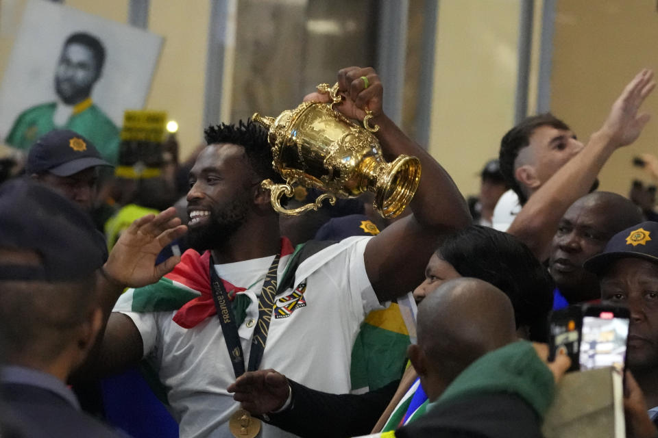 South Africa's Siya Kolisi holds the Webb Ellis trophy as fans welcome South Africa' Springbok team as they arrive at O.R Tambo's international airport in Johannesburg, South Africa, Tuesday Oct. 31, 2023, after the Rugby World Cup. (AP Photo/Themba Hadebe)