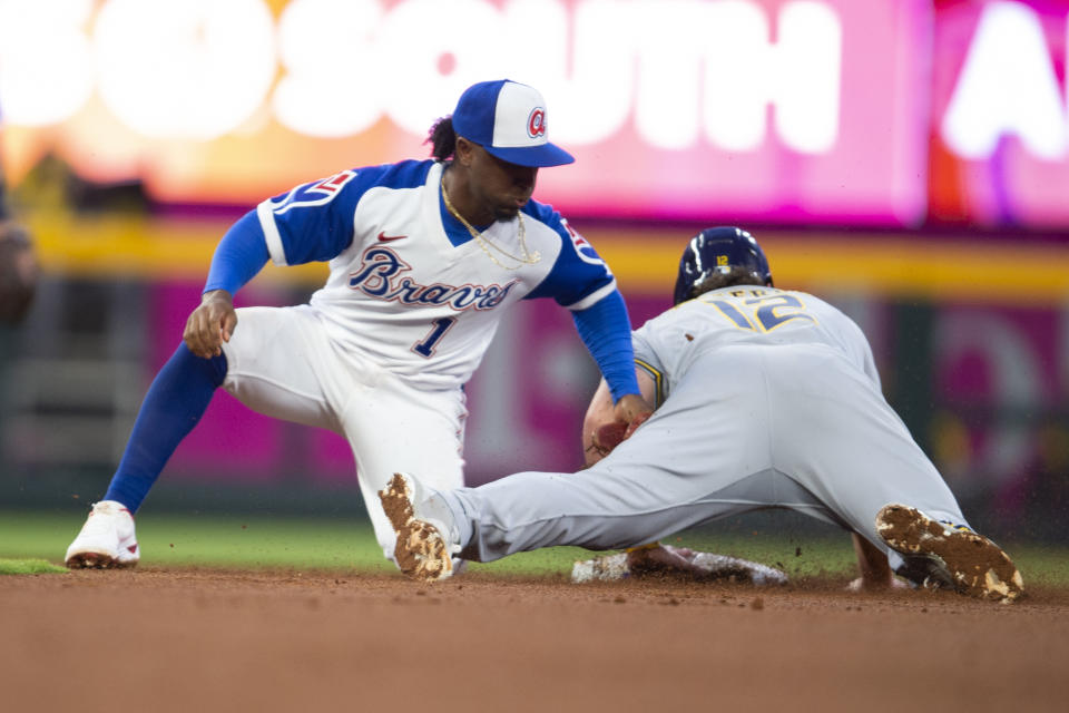 Atlanta Braves second baseman Ozzie Albies (1) tags out Milwaukee Brewers' Hunter Renfroe (12) during the first inning of a baseball game Saturday, May 7, 2022, in Atlanta. (AP Photo/Hakim Wright Sr)