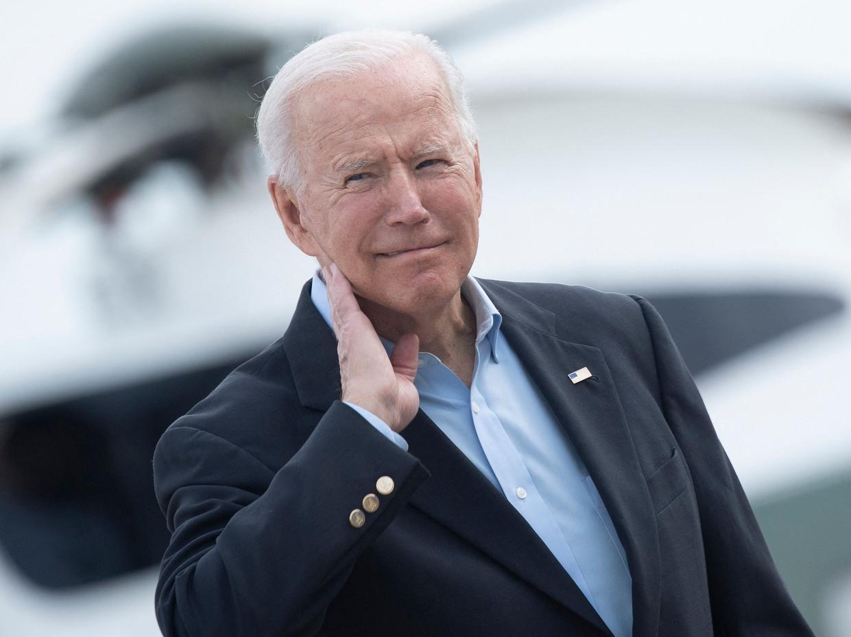 <p>US President Joe Biden wipes his neck after a cicada landed on him while boarding Air Force One at Andrews Air Force Base</p> (AFP via Getty Images)