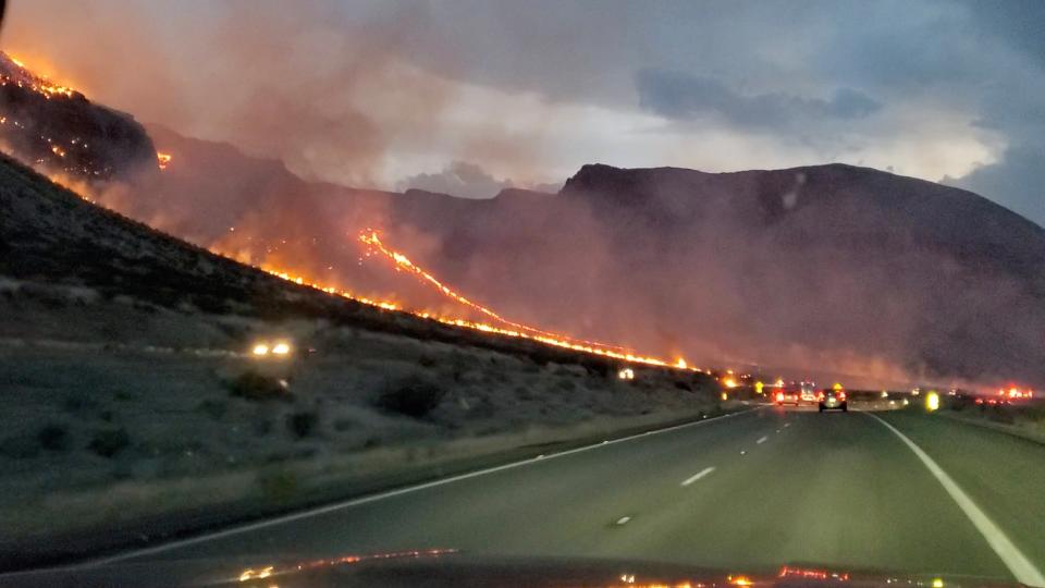 Flames are seen on side of the highway after a bushfire broke out, near St. George, Arizona on 12 July 2021, in this still image obtained from a social media video (Reuters)