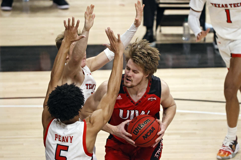 Incarnate Word's Marcus Larsson (15) tries to shoot around Texas Tech's Micah Peavy (5) and Mac McClung (0) during the first half of an NCAA college basketball game Tuesday, Dec. 29, 2020, in Lubbock, Texas. (AP Photo/Brad Tollefson)