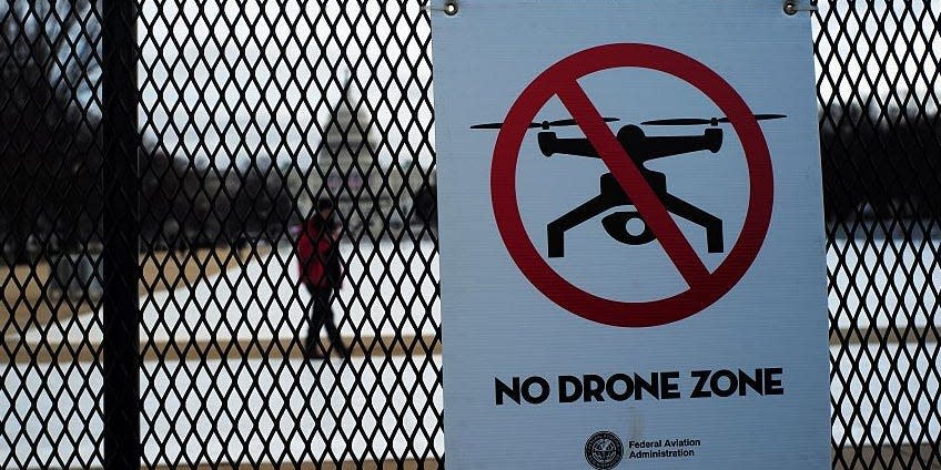 A sign reading "No Drone Zone" is placed on a security fence at the National Mall in Washington, DC