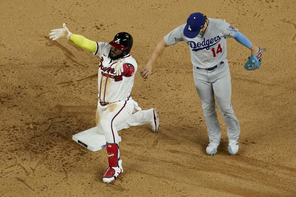 Atlanta Braves' Marcell Ozuna celebrates a RBI-double past Los Angeles Dodgers left fielder Enrique Hernandez during the sixth inning in Game 4 of a baseball National League Championship Series Thursday, Oct. 15, 2020, in Arlington, Texas. (AP Photo/David J. Phillip)