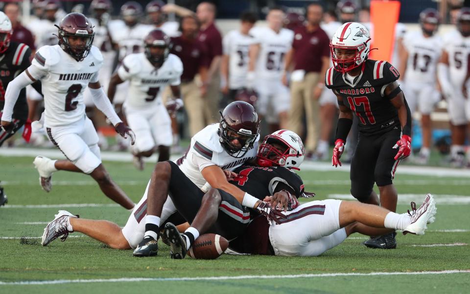 Benedictine's Wilkes Albert and Larson Little force Jenkins High quarterback Jeremiah James to fumble the ball during their game on Friday, August 18, 2023 at Memorial Stadium.