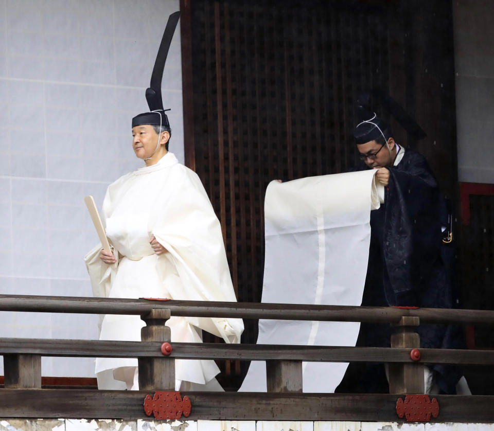 Japan's Emperor Naruhito, in a white robe, visits “Kashikodokoro”, a shrine at the Imperial Palace, in Tokyo, Tuesday, Oct. 22, 2019. Emperor Naruhito visited three Shinto shrines at the palace before proclaiming himself Japan’s 126th emperor in an enthronement ceremony. (Kyodo News via AP)