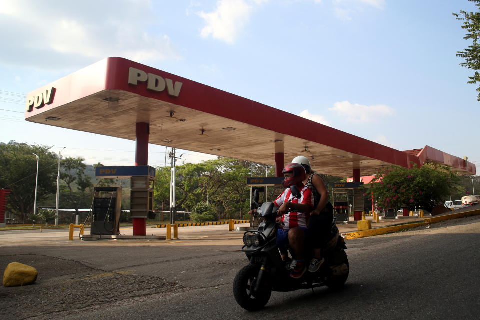People on a motorbike passes by a Venezuelan state oil company PDVSA gas station closed due to the lack of fuel, in San Cristobal, in the western state of Tachira, Venezuela January 27, 2022. Picture taken January 27, 2022. REUTERS/Carlos Eduardo Ramirez