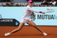 Iga Swiatek, of Poland, returns the ball to Beatriz Haddad Maia, of Brazil, during the Mutua Madrid Open tennis tournament in Madrid, Tuesday, April 30, 2024. (AP Photo/Paul White)