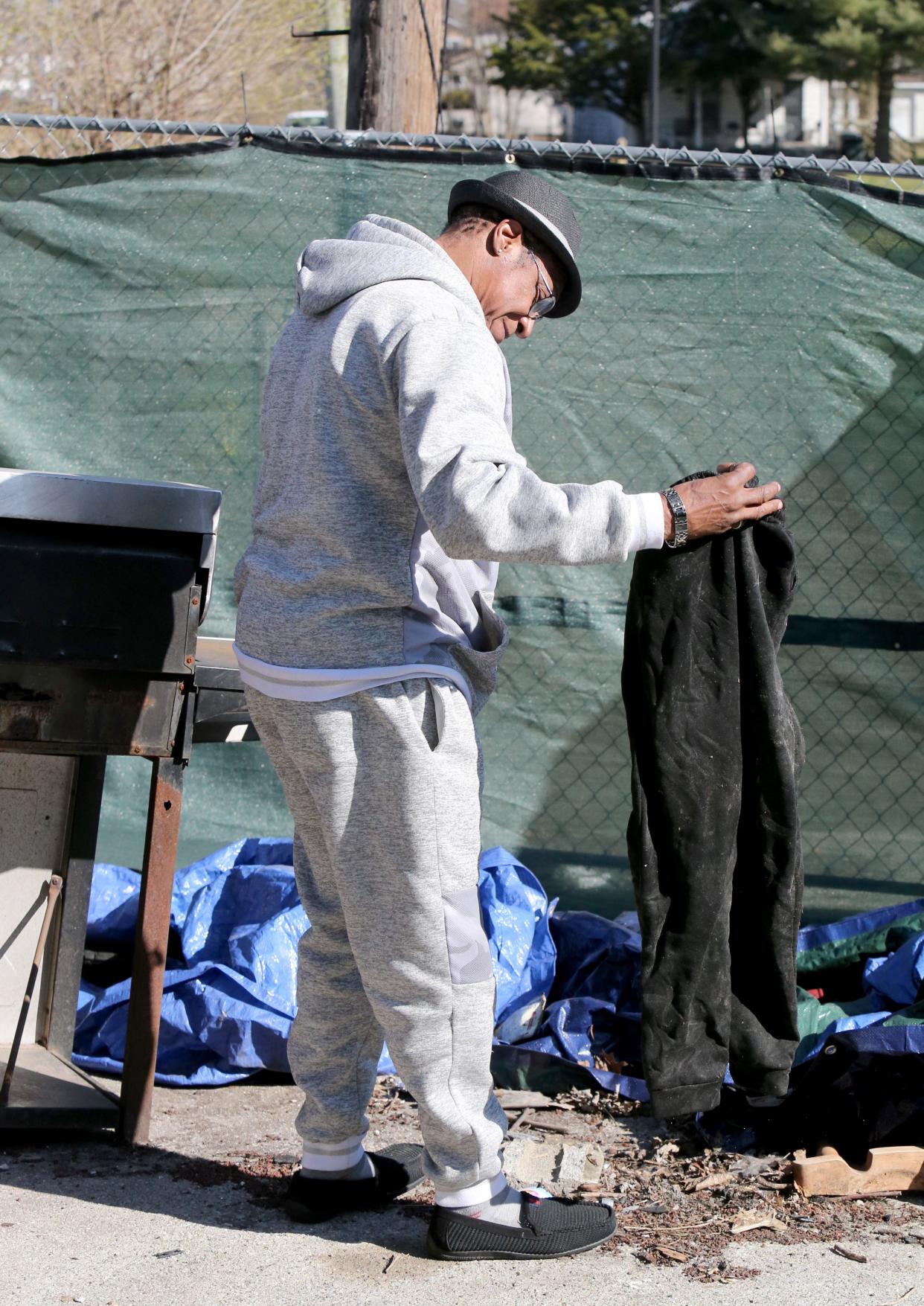 David Smith holds a pair of sweatpants that belonged to his 10-year-old son, Demetris, on Friday, March 29, 2024, at 222 N. LaPorte Ave. A house fire on Jan. 21 resulted in the deaths of six of his children.