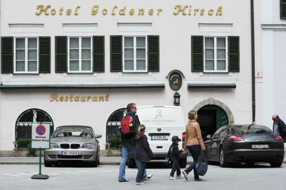 Tourists pass the front of the well-known luxury hotel Goldener Hirsch in Salzburg, Austria.