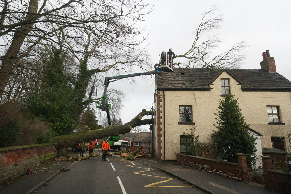 Workmen remove a fallen tree which has damaged the roof of a house in the village of Stanley in Derbyshire during high winds from Storm Pia, which is expected to cause disruption in parts of Scotland, the north of England and Northern Ireland. Picture date: Thursday December 21, 2023. (Photo by Jacob King/PA Images via Getty Images)