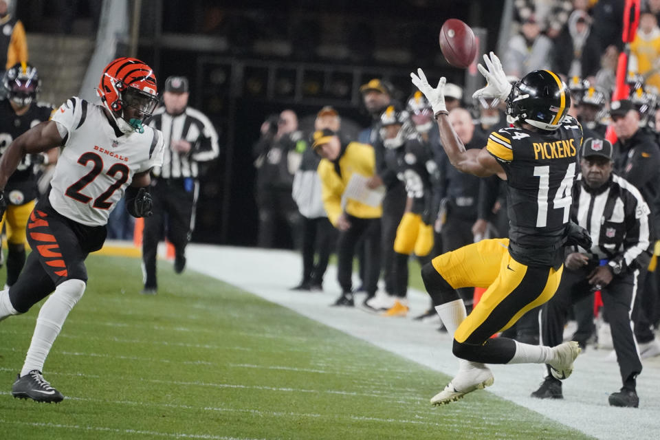 Pittsburgh Steelers wide receiver George Pickens (14) catches a pass as Cincinnati Bengals cornerback Chidobe Awuzie (22) moves in during the first half of an NFL football game Saturday, Dec. 23, 2023, in Pittsburgh. (AP Photo/Gene J. Puskar)