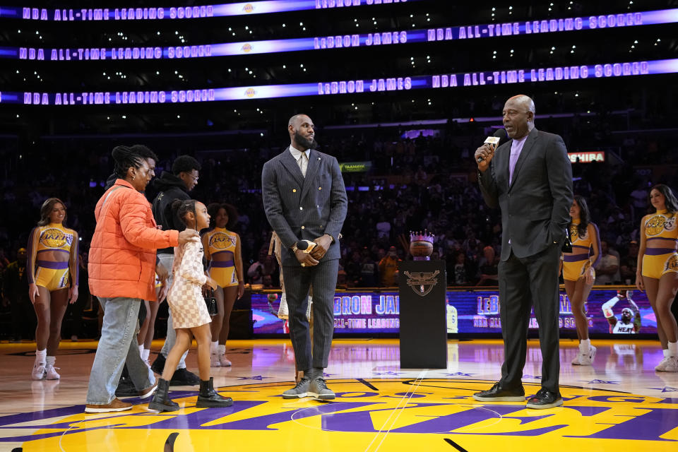 Los Angeles Lakers forward LeBron James, center, is introduced by former Laker James Worthy, right, during a ceremony honoring James as the NBA's all-time leading scorer before an NBA game against the Milwaukee Bucks on Thursday, Feb. 9, 2023, in Los Angeles. James passed Kareem Abdul-Jabbar to earn the record during Tuesday's NBA game against the Oklahoma City Thunder. (AP Photo/Mark J. Terrill)