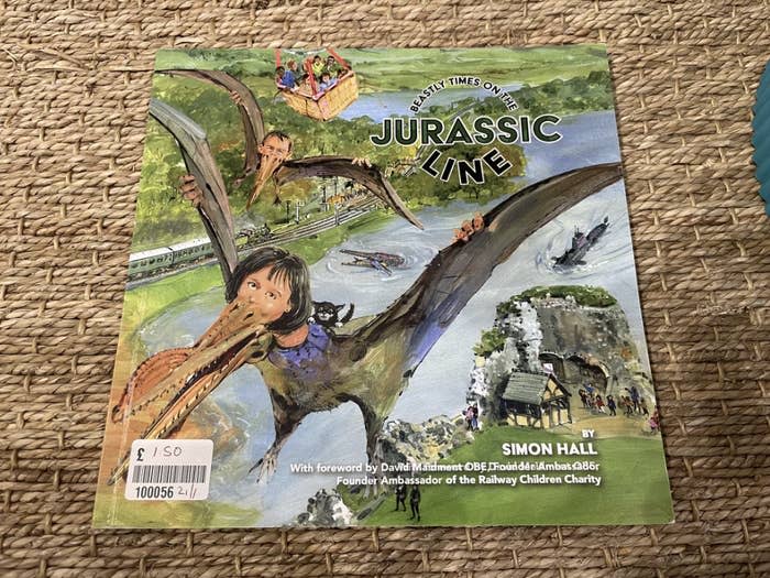 Cover of "Jurassic Line" book by Simon Hall featuring illustrations of dinosaurs and trains with a foreword by David Maidment