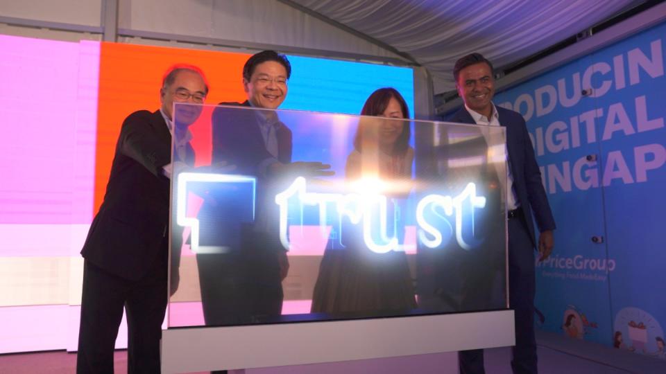 Image showing guests at the Trust Bank launch pressing on a lighted launch mechanism to officially launch the digital bank.