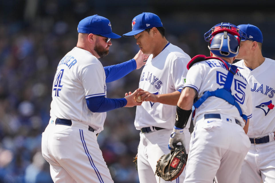 Toronto Blue Jays starting pitcher Hyun Jin Ryu (99), back middle, hands the ball to manager John Schneider (14) after being pulled during the fifth inning of a baseball game against the Boston Red Sox in Toronto, Sunday, Sept. 17, 2023. (Andrew Lahodynskyj/The Canadian Press via AP)