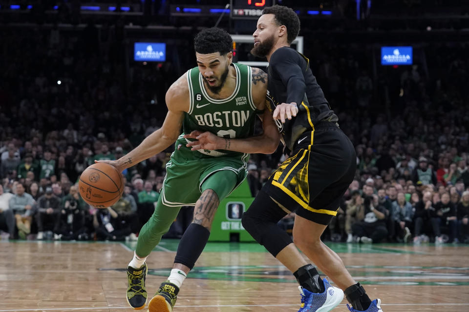 Boston Celtics forward Jayson Tatum, left, drives past Golden State Warriors guard Stephen Curry, right, in the second half of an NBA basketball game, Thursday, Jan. 19, 2023, in Boston. (AP Photo/Steven Senne)