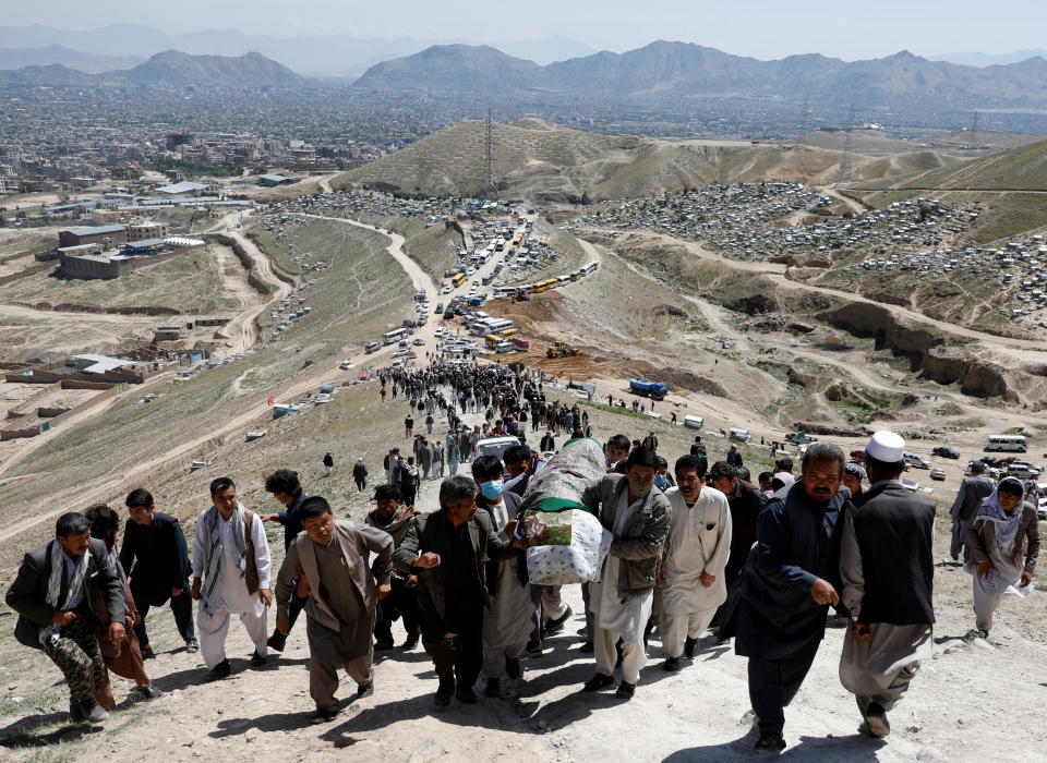 Men carry the coffin of a victim of Saturday's girls' school explosion during a mass funeral ceremony in Kabul, Afghanistan on May 9, 2021. / Credit: STRINGER / REUTERS