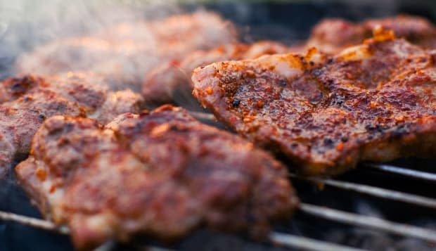 AJRNHW Delicious chuck steaks on the grill Shallow depth of fieldtongs