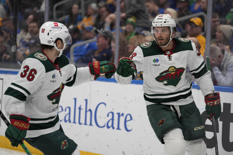 Minnesota Wild's Ryan Hartman, right, is congratulated by Mats Zuccarello (36) after scoring during the third period of an NHL hockey game against the St. Louis Blues Wednesday, March 15, 2023, in St. Louis. (AP Photo/Jeff Roberson)
