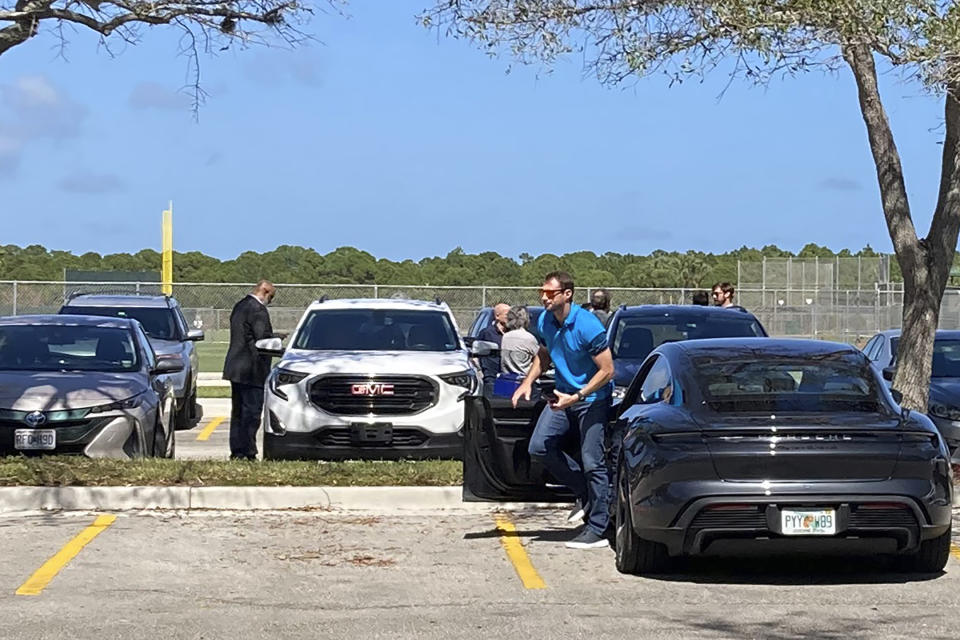 New York Mets pitcher Max Scherzer gets out of his car as he arrives for baseball labor talks at Roger Dean Stadium in Jupiter, Fla., Wednesday, Feb. 23, 2022. At far left is Major League Baseball Players Association executive director Tony Clark. (AP Photo/Ron Blum)