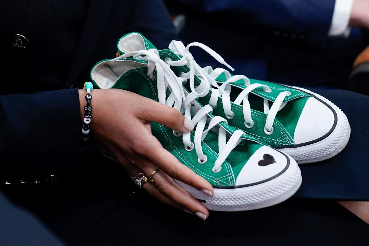 Camila Alves McConaughey holds the green Converse tennis shoes similar to those worn by Uvalde shooting victim Maite Yuleana Rodriguez, 10, as Matthew McConaughey, a native of Uvalde, Texas, joins White House press secretary Karine Jean-Pierre for the daily briefing at the White House in Washington, Tuesday, June 7, 2022. (AP Photo/Susan Walsh) ORG XMIT: DCSW316