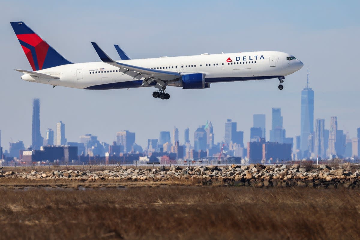 A Boeing 767 passenger aircraft of Delta airlines arrives at JFK International Airport in New York as the Manhattan skyline looms in the background on February 7, 2024. A Delta flight lost its emergency slide mid-air on 26 April  (AFP via Getty Images)