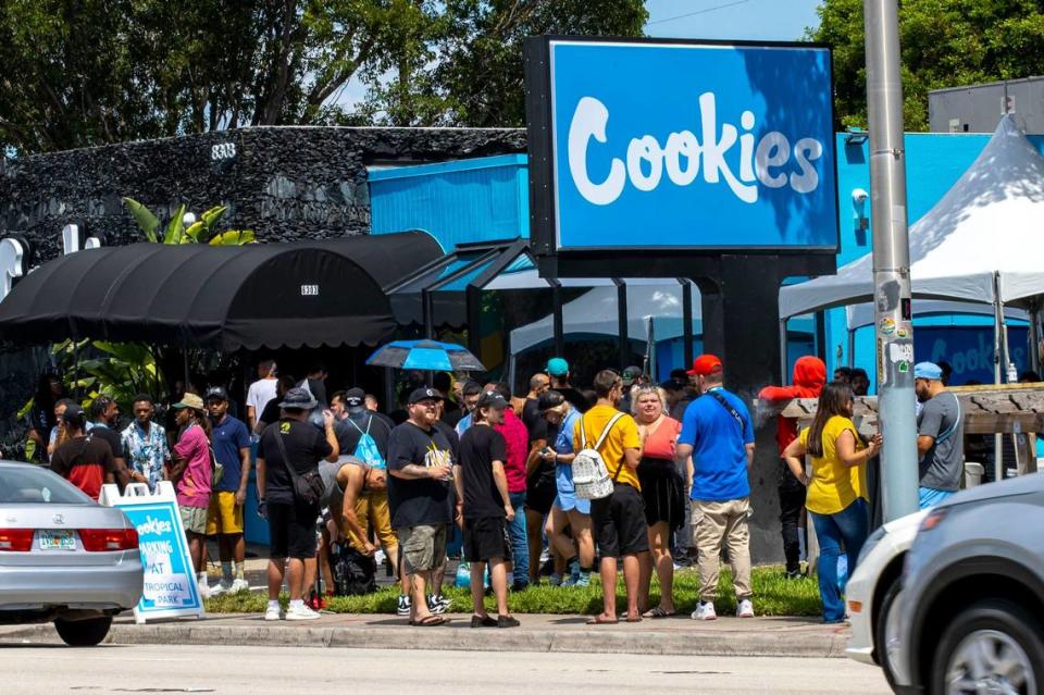 Clientes esperan en una fila que rodea el dispensario y continúa en la calle durante la gran inauguración de Cookies Miami, el primer y único dispensario de marihuana propiedad de miembros de una minoría de la Florida, en Miami, Florida, el 13 de agosto de 2022.