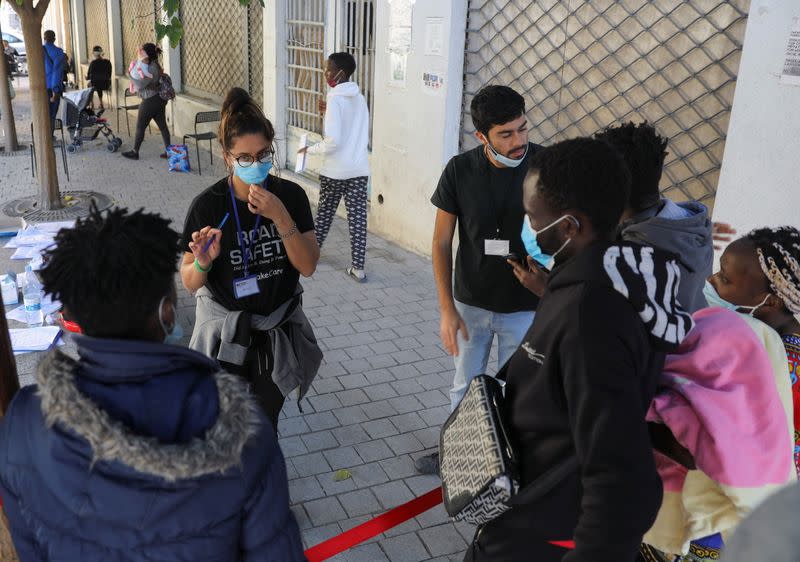 Volunteers assist migrants outside the Holy Cross Catholic Church next to the United Nations buffer zone in Nicosia