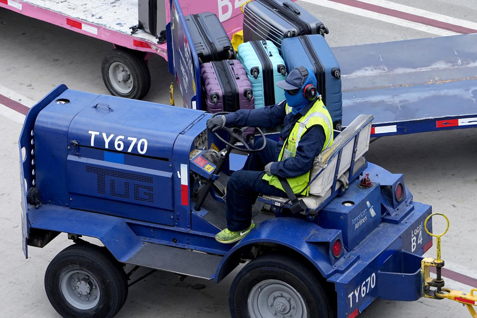 A baggage handler at Sky Harbor International Airport is covered to protect against the sun, Monday, July 10, 2023, in Phoenix. (AP Photo/Matt York)