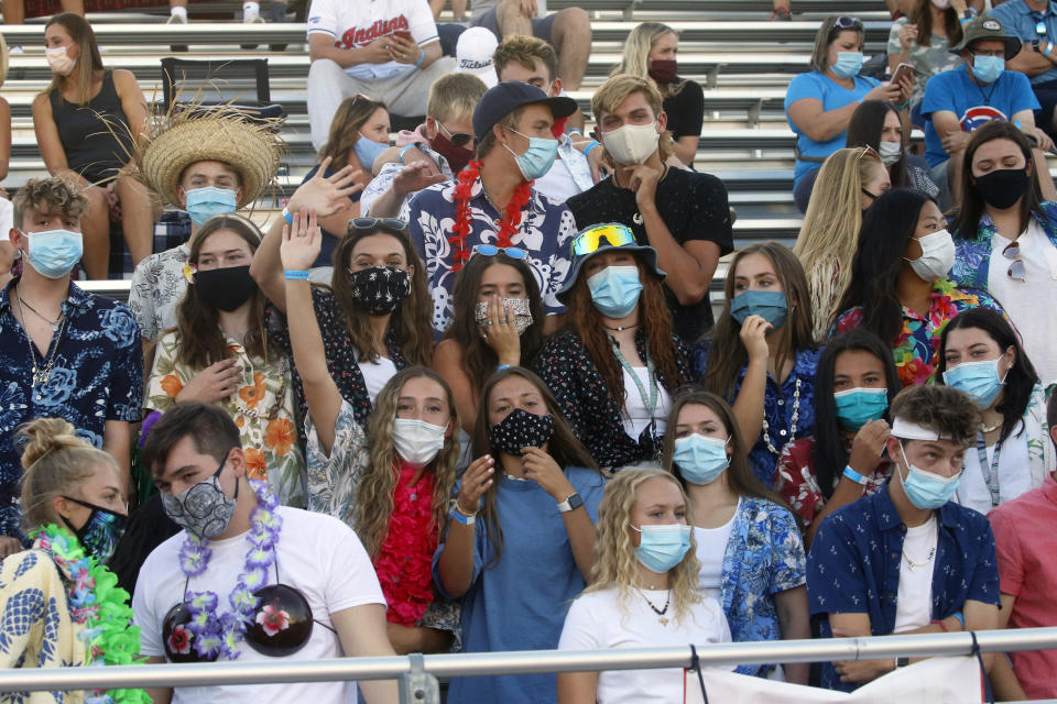 Herriman fans look on during a high school football game against Davis on Thursday, Aug. 13, 2020, in Herriman, Utah. Utah is among the states going forward with high school football this fall despite concerns about the ongoing COVID-19 pandemic that led other states and many college football conferences to postpone games in hopes of instead playing in the spring. (AP Photo/Rick Bowmer)
