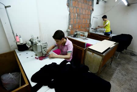 Muhamed (L), a Syrian refugee boy, and his older brother Mustafa work at a small textile factory in Istanbul, Turkey, June 24, 2016. REUTERS/Murad Sezer