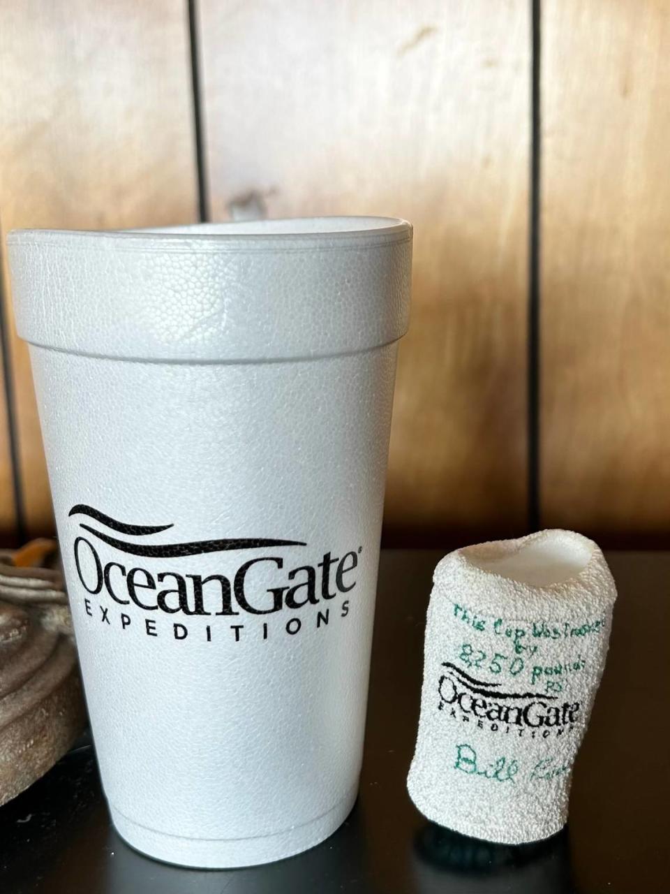 A crushed styrofoam cup signed by Bill Price, right, shows the effect of undersea pressure at the depth of the Titan submersible’s dive to the Titanic shipwreck. The cups were placed in an unpressurized spot outside the Titan and kept as souvenirs.