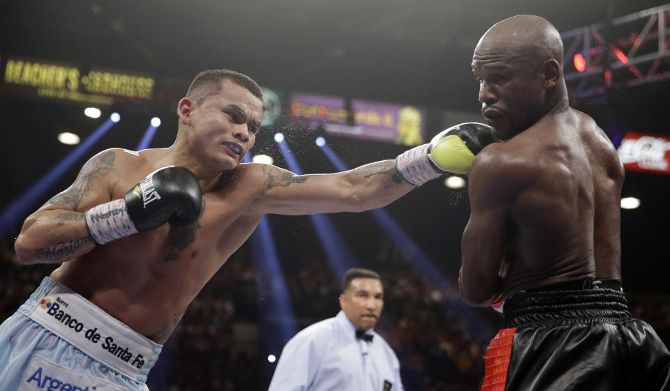Marcos Maidana, left, from Argentina, throws a left at the head of Floyd Mayweather Jr. in their WBC-WBA welterweight title boxing fight Saturday, May 3, 2014, in Las Vegas. (AP Photo/Isaac Brekken)