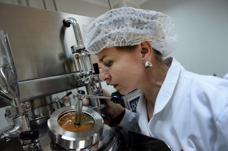 An assistant checks the texture of bee vemom based cream at the factory of the Research and Development Institute of Beekeeping, in Bucharest, on March 18, 2014