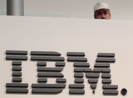 A worker is pictured behind a logo at the IBM stand on the CeBIT computer fair in Hanover February 26, 2011. REUTERS/Tobias Schwarz